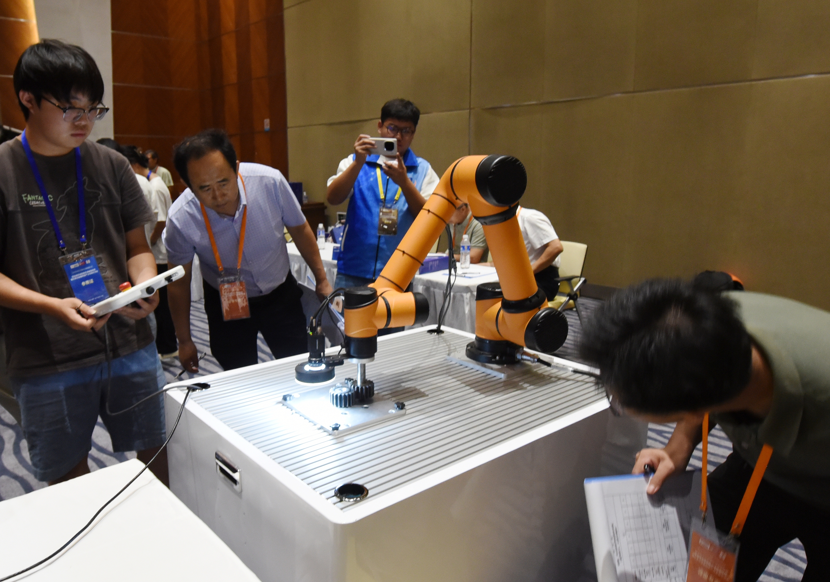 2025年中国大学生机械工程创新创意大赛智能精密装配赛京津冀鲁联赛现场,评委对参赛选手进行实操调试评比。